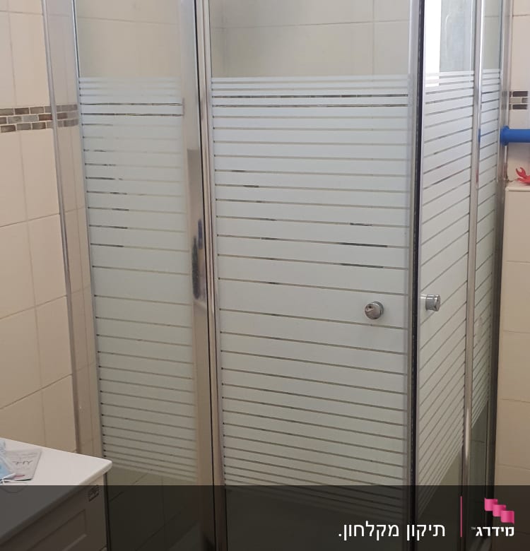 מקלחון זכוכית עם דלתות הזזה וראש מקלחת